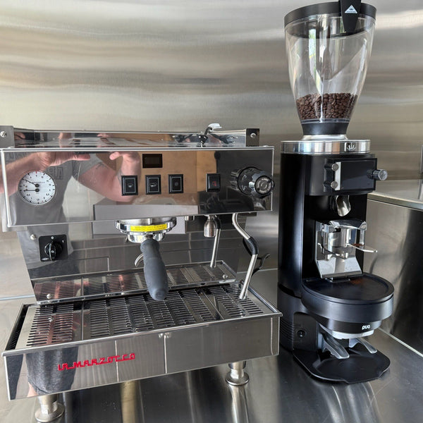 E65W GbS beside a stainless Linea on an all-steel café bar